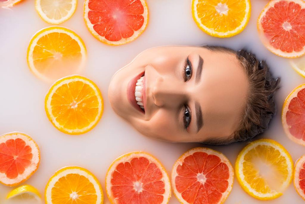 Charming smiling woman taking spa citrus bath - Foto, imagen