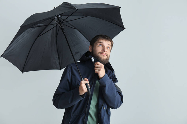 Handsome man with umbrella on white background - Photo, Image