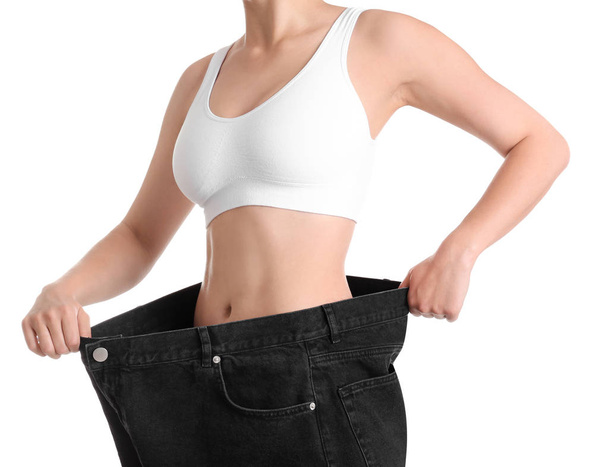 Young slim woman wearing oversized jeans on white background, closeup - Zdjęcie, obraz