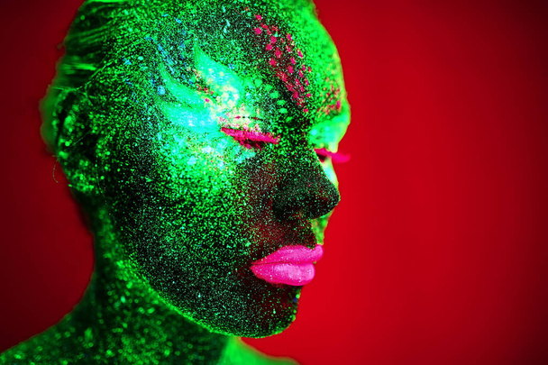 Portrait of a girl painted in fluorescent powder. - Zdjęcie, obraz