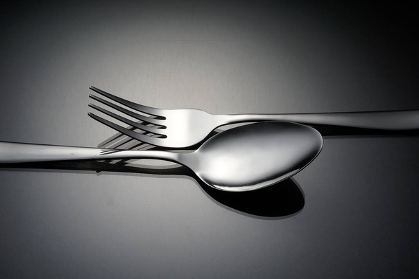 silverware, stainless fork and spoon on grey surface  - Foto, Imagen