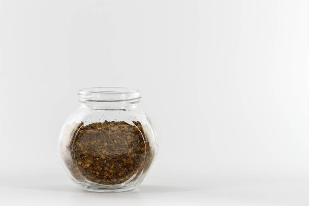 brown pile of spicy pepper in glass jar isolated on white in studio  - Foto, Imagem