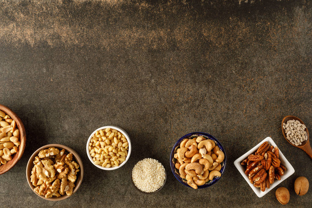 Frame made of different types of nuts in bowls - Foto, imagen