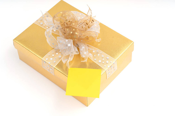 Blank adhesive note on gold gift box on white background - Fotografie, Obrázek