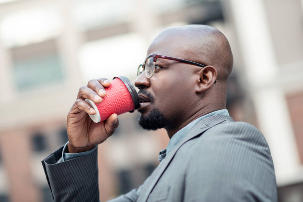 Young African-American businessman thinking and drinking coffee - 写真・画像