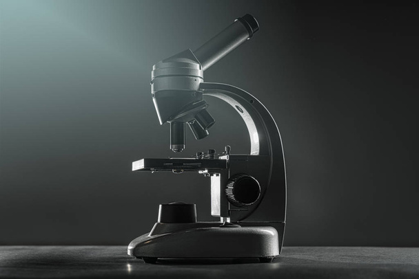 close up of a silver microscope, with black background - Фото, изображение