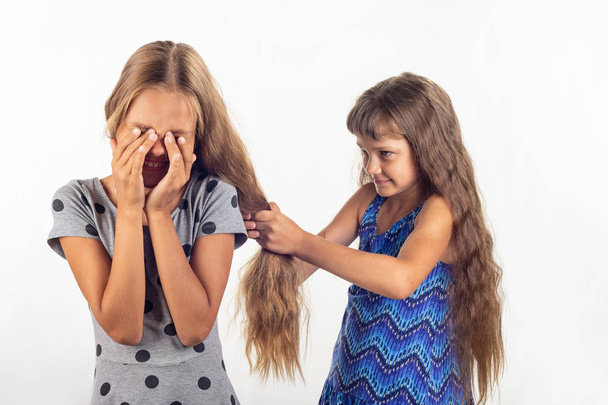 Mädchen zieht ein anderes Mädchen an den Haaren - Foto, Bild