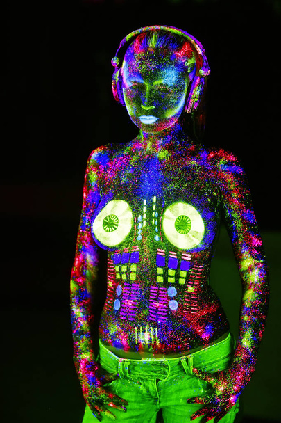 Concept. On the body of a girl painted DJ deck. Half-naked girl painted in UV colors - Φωτογραφία, εικόνα