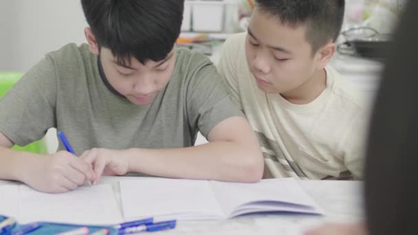 asiatische Junge Hausaufgaben zu Hause zusammen. - Filmmaterial, Video