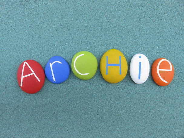 archie, männlicher Vorname bestehend aus bunten Steinen über grünem Sand - Foto, Bild