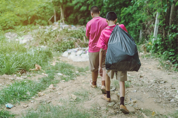 Erkek öğrenciler atık toplamak için sınıftaki çöpleri atmaya yardım ederler - Fotoğraf, Görsel