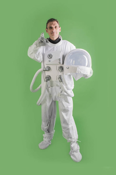 ヘルメットの宇宙服を持ち、笑顔を浮かべた宇宙飛行士 - 写真・画像