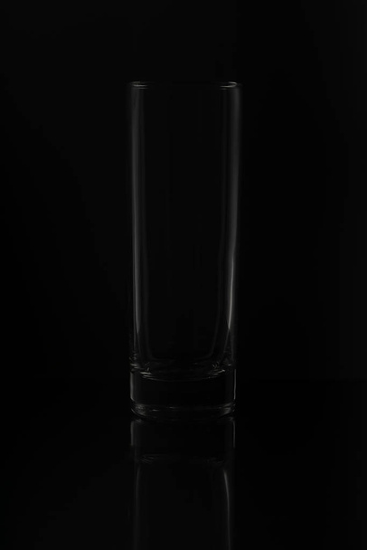 clear empty glass isolated on black background in studio  - 写真・画像
