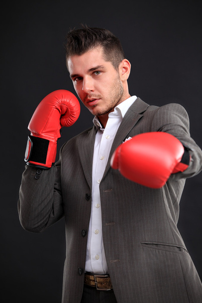 Business man ready to fight with boxing gloves - isolated over black background - Foto, immagini