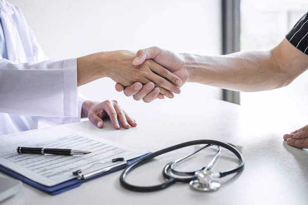 Professional female doctor in white coat shaking hand with patie - Foto, Imagen