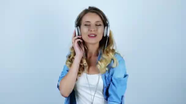 young beautiful sexy blonde woman dancing in headphones on isolated white background - Imágenes, Vídeo