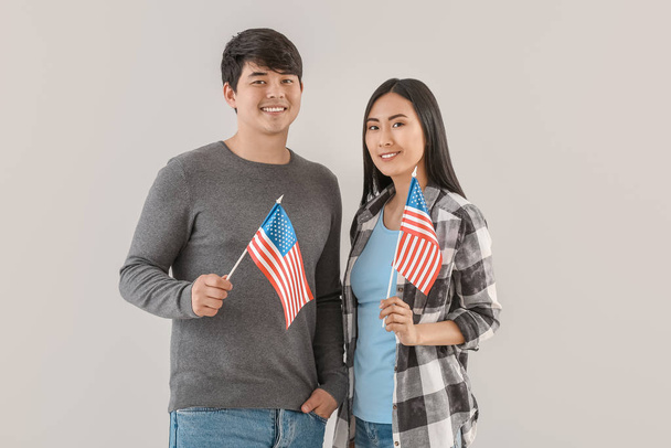 Young people with USA flags on light background - Photo, Image