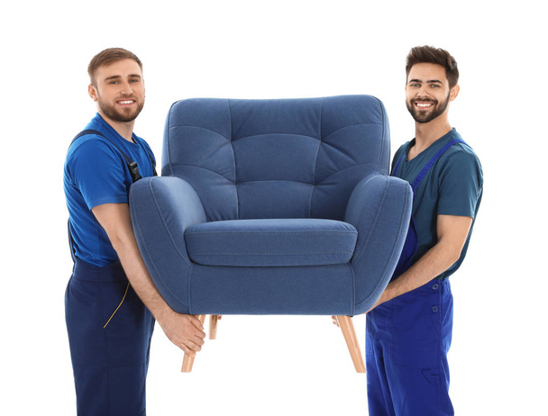Young workers carrying armchair isolated on white. Moving service - Фото, зображення