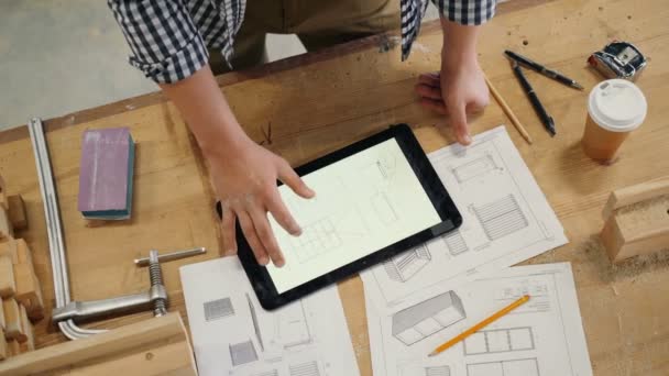 Mão masculina tocando tela tablet com desenho técnico de móveis na oficina
 - Filmagem, Vídeo