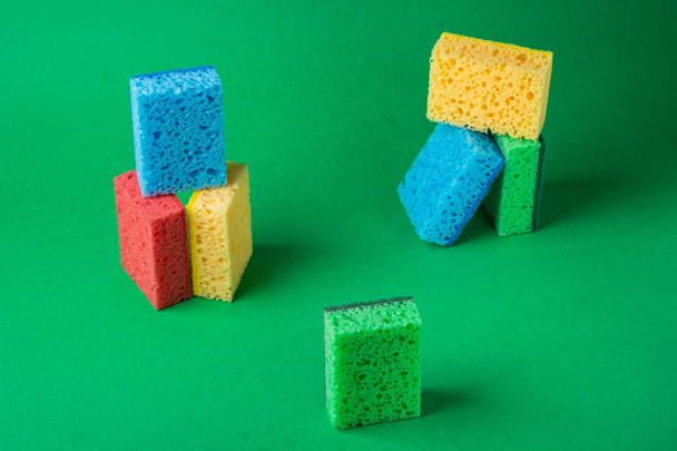 Стек геометрических блоков строительство абстрактных губок в красном, желтом, синем, зеленом цветах, на зеленом фоне бумаги, пространство для копирования
 - Фото, изображение