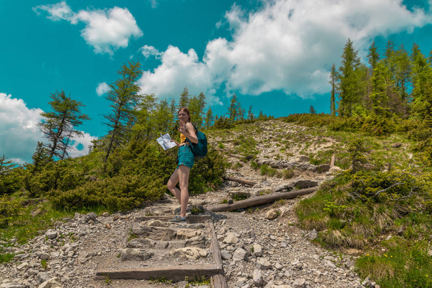Dziewczyna turysta z plecaka podnosi kamienie pod górę - Zdjęcie, obraz