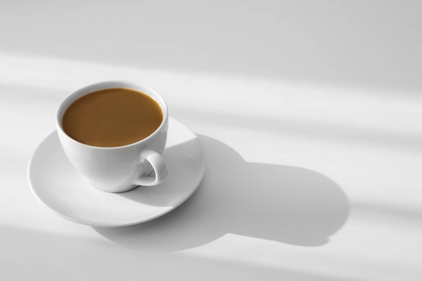 Cup of hot aromatic coffee on white table. Space for text - Foto, immagini