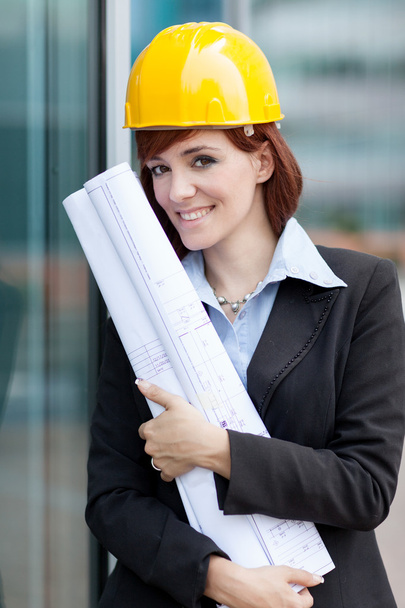 Portrait of female constructor with blueprints - Foto, afbeelding