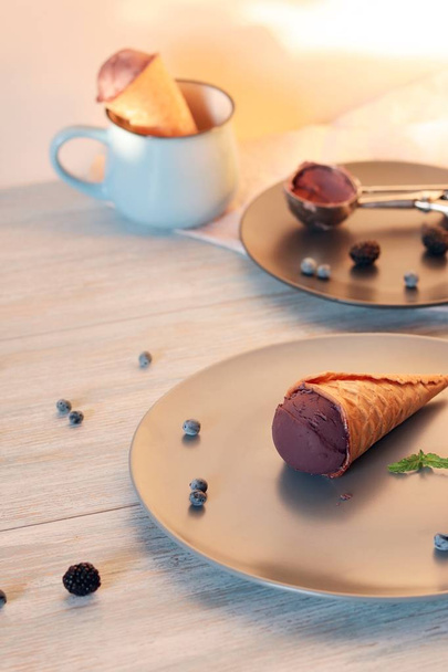 Kotitekoinen suklaajäätelö vohvelikekseissä, marjat puupöydällä, terveellinen jälkiruoka
 - Valokuva, kuva