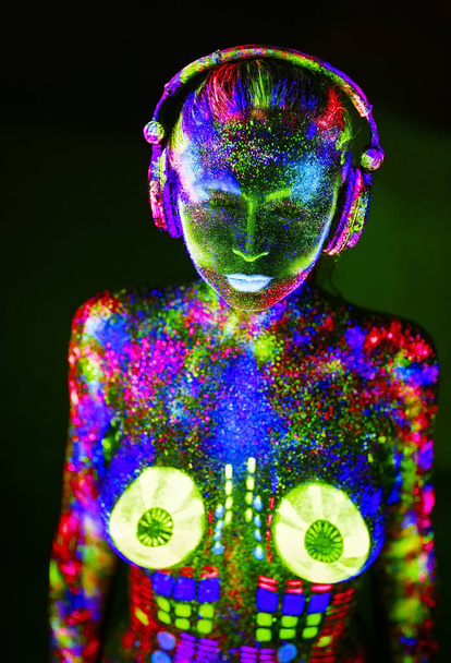 Concept. On the body of a girl painted DJ deck. Half-naked girl painted in UV colors - Фото, изображение