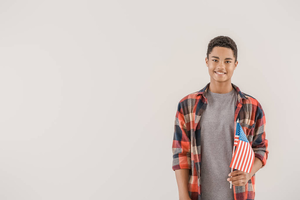 African-American teenage boy with USA flag on light background - Fotó, kép
