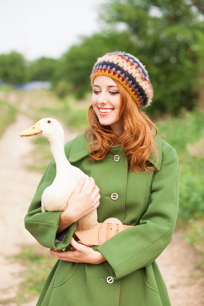 Redhead girl with duck at outdoor. - Valokuva, kuva