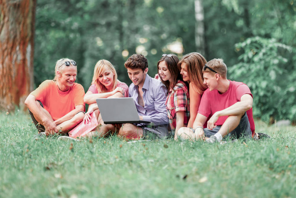 een groep studenten met laptop ontspannen in het Park op een Sunny  - Foto, afbeelding
