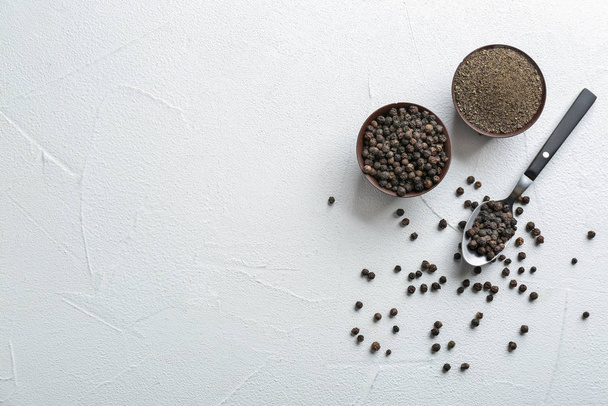Ground black pepper and corns on light table, top view. Space for text - Photo, Image