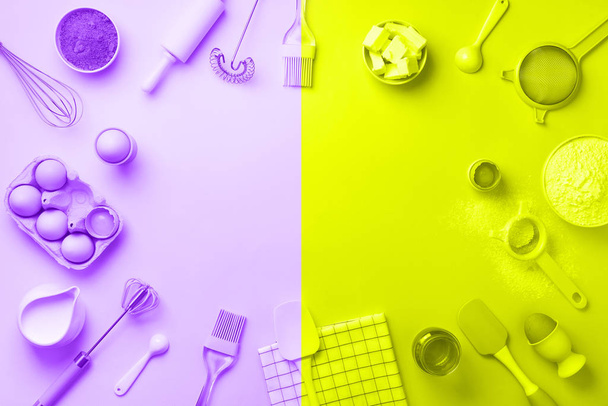 Bakery ingredients over trendy neon yellow and violet color background - butter, sugar, flour, eggs, oil, spoon, rolling pin. Baking frame, cooking concept. Top view, copy space. Flat lay - Photo, Image