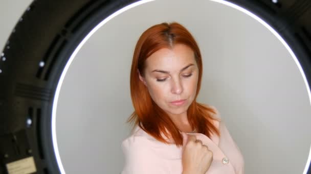 Krásná zrzavá dospělá ženská modelka ve středním věku, která pózala před kamerou ve studiu - Záběry, video