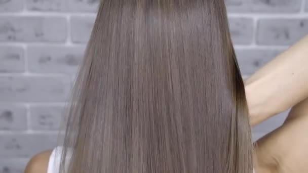 Resultaat na lamineren en haar rechttrekken in een schoonheidssalon voor een meisje met bruin haar. Hair Care concept - Video