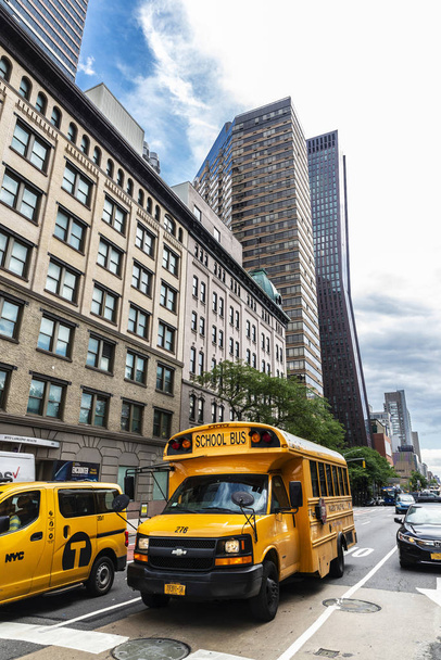 Gele schoolbus en een taxi in New York City, USA - Foto, afbeelding