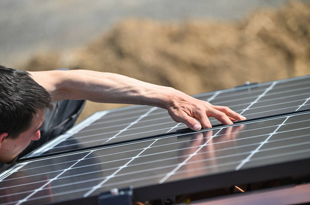 住宅屋根の金属インフラに太陽光パネルを設置する作業員 - 写真・画像