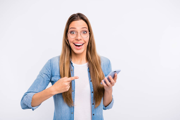Photo of pretty excited nice optimistic lucky lady pointing forefinger on telephone isolated grey background - Foto, afbeelding