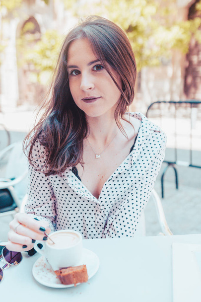 Beautiful woman drinking a coffee on the terrace in Madrid city - Photo, image