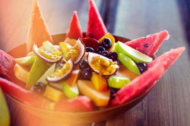 Bowl of healthy fresh fruit salad on wooden background. - Photo, Image