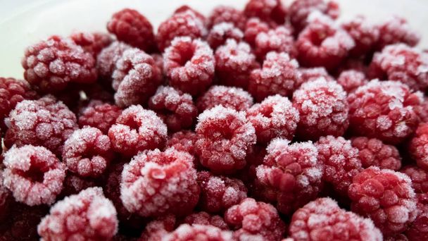 Background of frozen raspberries. Ripe raspberries with frosty freshness. - Fotografie, Obrázek