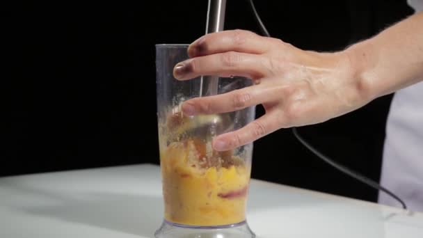 Woman cooking healthy breakfast, peach mixing into blender for smoothie - Felvétel, videó