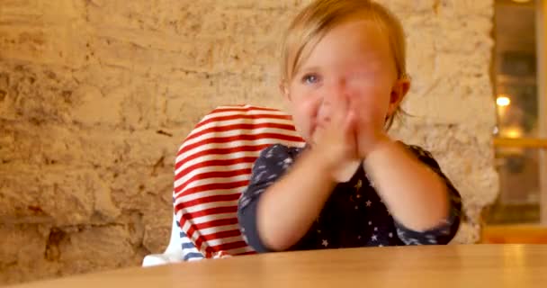 Παιδί που κάθεται σε καρεκλάκι παλαμάκια με χέρια - Πλάνα, βίντεο