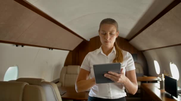 Zakenvrouw in de lucht prive jet surfen internet op digitale pad - Video
