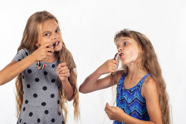 Due ragazze ardentemente mordere e succhiare caramelle caramello
 - Foto, immagini