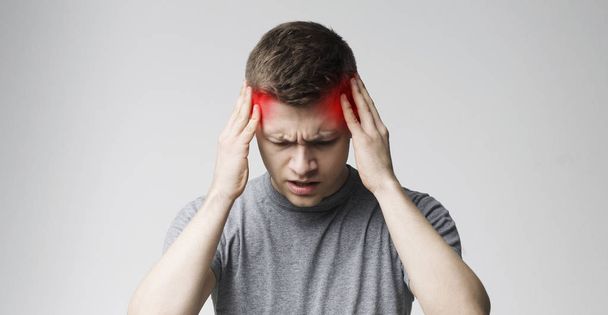 Jovem sofrendo de dor de cabeça após o dia de trabalho duro
 - Foto, Imagem