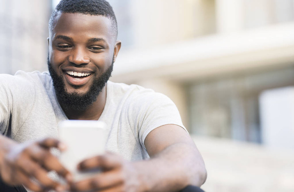 Счастливый африканский парень, имеющий видео-звонок с родителями
 - Фото, изображение