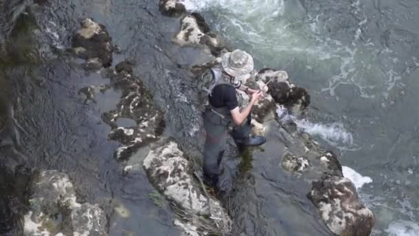 Slow motion aerial view of fisherman fishing in a river with a fishing rod.  - Footage, Video
