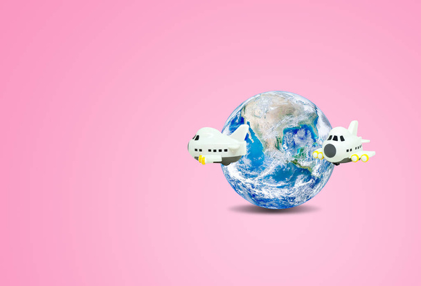 Reise- und Urlaubskonzept: Flugzeug umfliegt blauen Planeten Erde Globus mit rosa Hintergrund. (Elemente dieses Bildes stammen von nasa.) - Foto, Bild